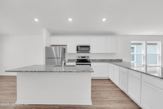 37143 Whippoorwill Ct, Hilliard, FL 32046 - kitchen with stainless steel appliances, light stone countertops, light wood-style flooring, white cabinetry, and recessed lighting