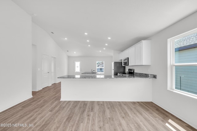 37143 Whippoorwill Ct, Hilliard, FL 32046 - kitchen featuring stainless steel appliances, light stone counters, light wood-type flooring, white cabinetry, and recessed lighting