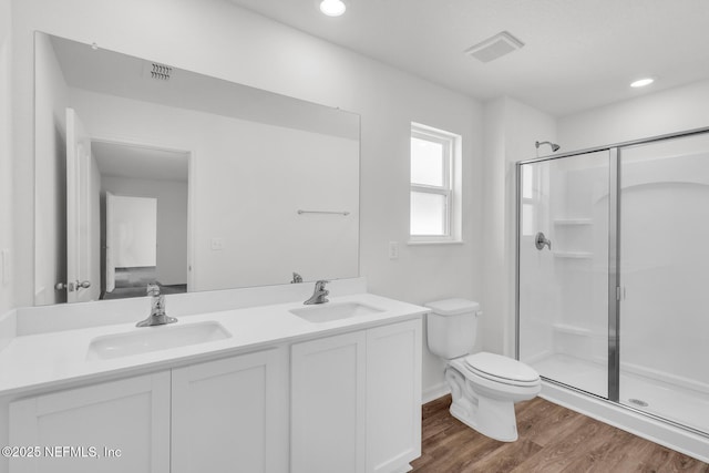 37143 Whippoorwill Ct, Hilliard, FL 32046 - bathroom with a shower stall, toilet, wood finished floors, double vanity, and recessed lighting