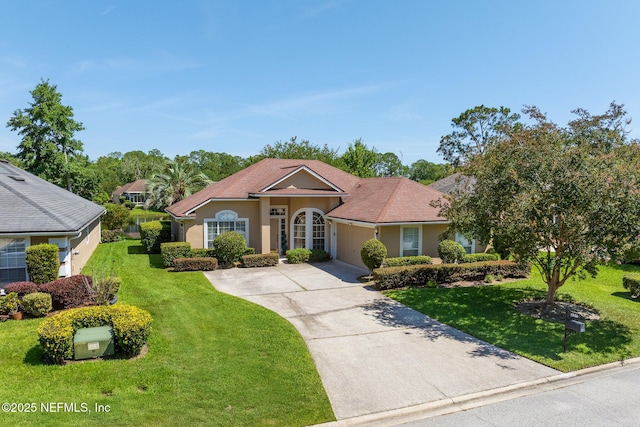 1530 Blue Heron Ct, Fleming Island, FL 32003 - view of front of home featuring a front yard, driveway, an attached garage, and stucco siding