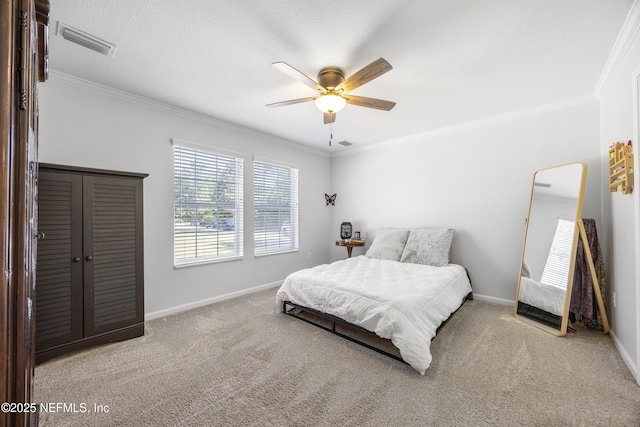 carpeted bedroom with ornamental molding, baseboards, and ceiling fan