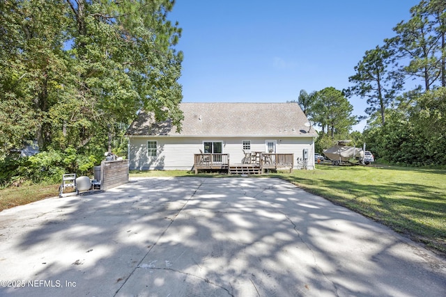 back of house with a wooden deck and a lawn