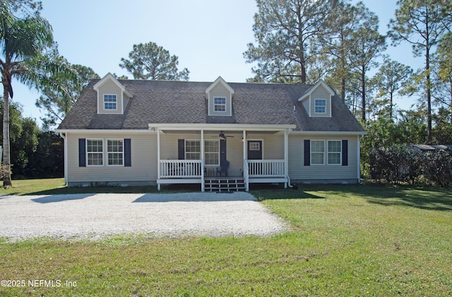 cape cod house with a porch, ceiling fan, a front lawn, and a shingled roof