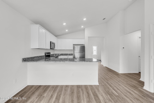 37322 Whisper Way, Hilliard, FL 32046 - kitchen featuring stainless steel appliances, stone countertops, a peninsula, light wood-style flooring, and white cabinetry