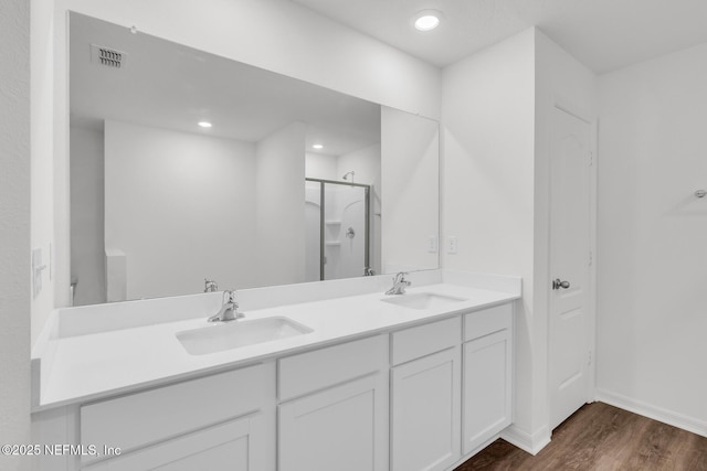 37127 Whippoorwill Ct, Hilliard, FL 32046 - bathroom featuring wood finished floors, a shower stall, double vanity, baseboards, and recessed lighting