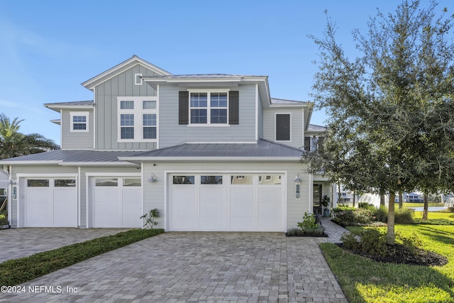 228 Rum Runner Way, Saint Johns, FL 32259 - view of front of home featuring a garage, board and batten siding, decorative driveway, and metal roof
