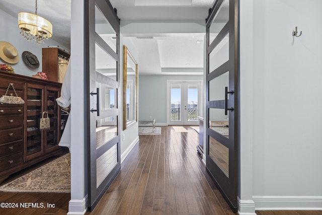 228 Rum Runner Way, Saint Johns, FL 32259 - hall featuring french doors, dark wood-style floors, baseboards, a chandelier, and a tray ceiling