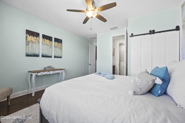 228 Rum Runner Way, Saint Johns, FL 32259 - bedroom with wood finished floors, baseboards, a barn door, and ceiling fan