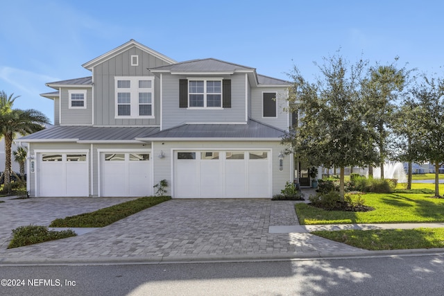228 Rum Runner Way, Saint Johns, FL 32259 - view of front of property with a garage, board and batten siding, decorative driveway, metal roof, and a front yard