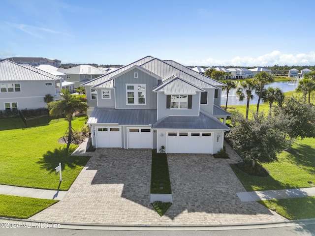 228 Rum Runner Way, Saint Johns, FL 32259 - view of front of house featuring a water view, an attached garage, decorative driveway, a front lawn, and a standing seam roof