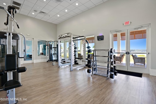 228 Rum Runner Way, Saint Johns, FL 32259 - gym featuring french doors, a high ceiling, a paneled ceiling, wood finished floors, and baseboards