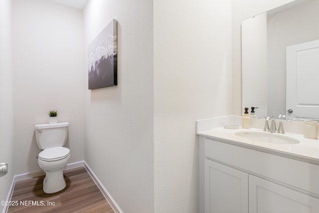 573 Holly Lakes Dr, Orange Park, FL 32073 - half bathroom with toilet, vanity, wood finished floors, and baseboards