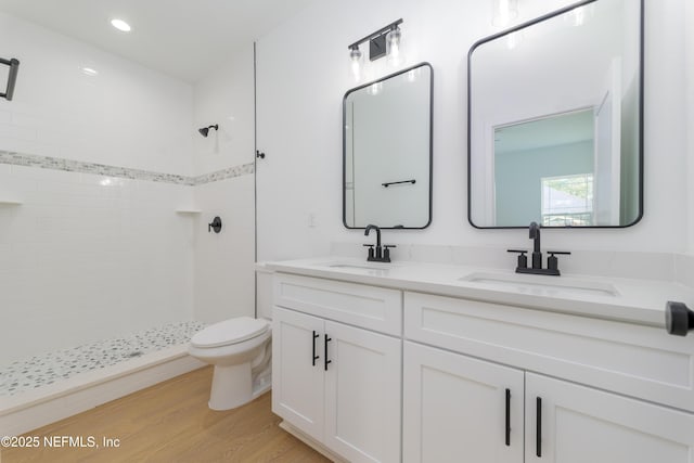 965 Florida St, Fleming Island, FL 32003 - bathroom featuring tiled shower, toilet, wood finished floors, double vanity, and recessed lighting