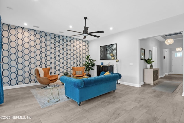 living area with recessed lighting, a ceiling fan, baseboards, an accent wall, and wallpapered walls