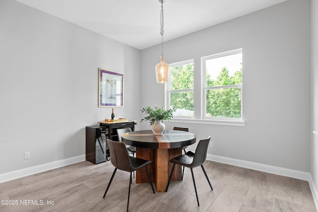 dining area with baseboards and light wood-style floors
