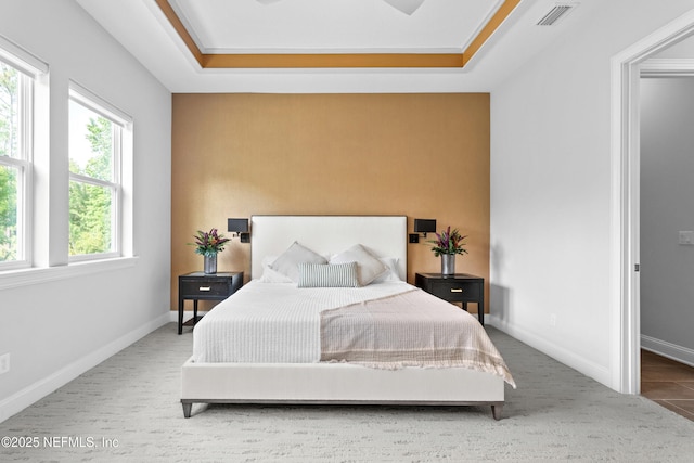 bedroom featuring baseboards, carpet floors, and a raised ceiling