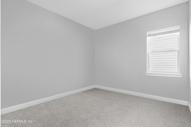 carpeted empty room with baseboards