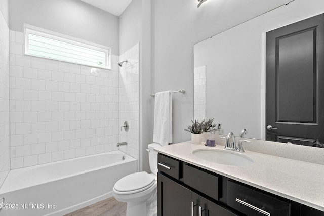 full bath with toilet, wood finished floors, washtub / shower combination, and vanity