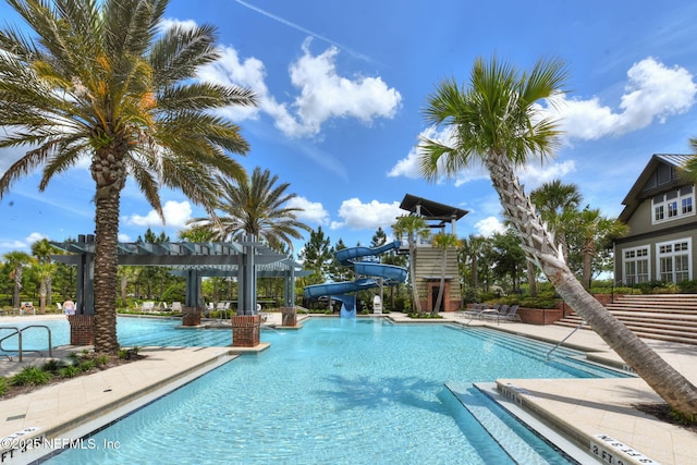 community pool featuring a water slide and a pergola