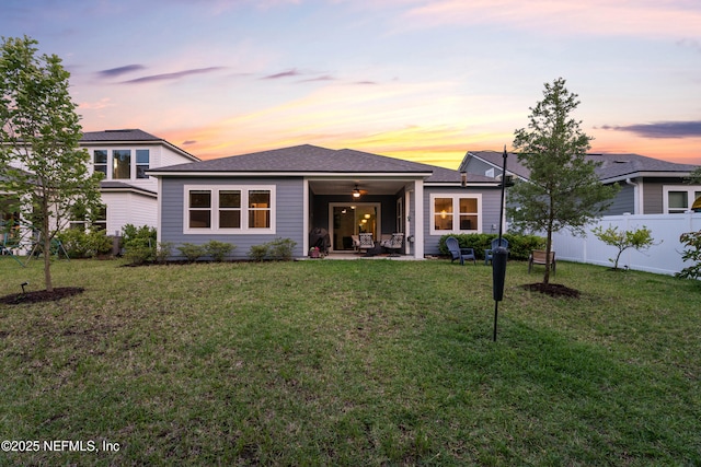 back of property at dusk featuring ceiling fan and a patio area