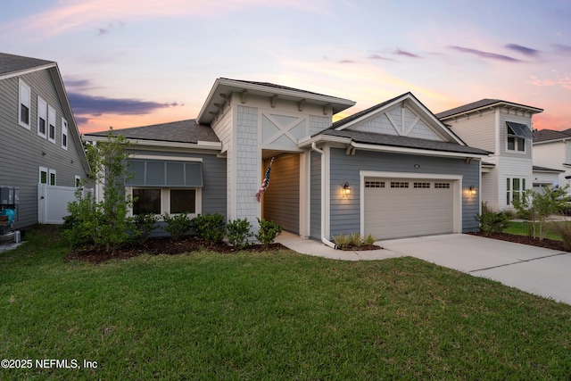 view of front of house featuring driveway, an attached garage, and a shingled roof