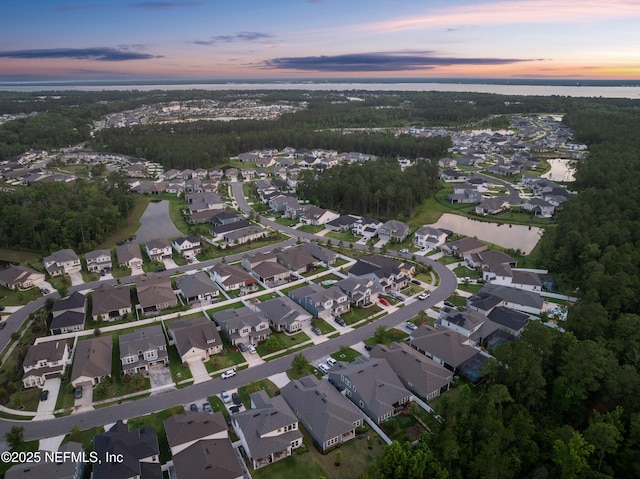 aerial view of property and surrounding area with nearby suburban area and a large body of water