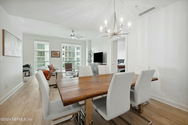 dining space featuring wood finished floors, a chandelier, baseboards, and ceiling fan