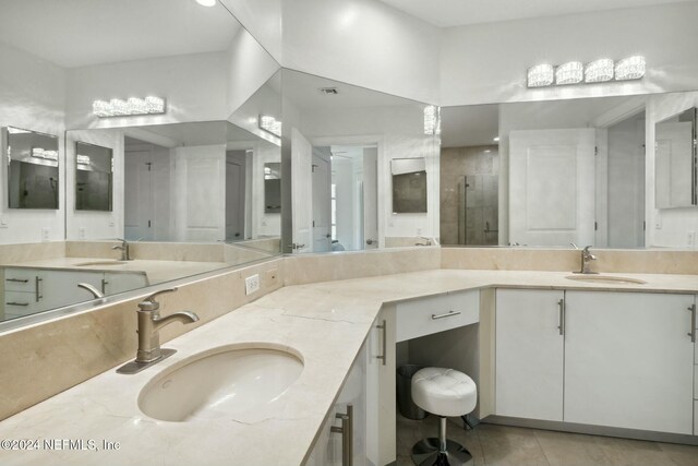 bathroom featuring tile patterned floors, double vanity, and a shower stall