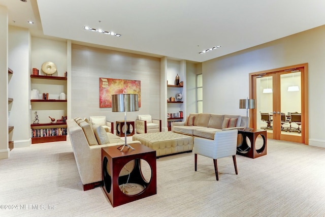 living area featuring light carpet, french doors, built in features, and baseboards