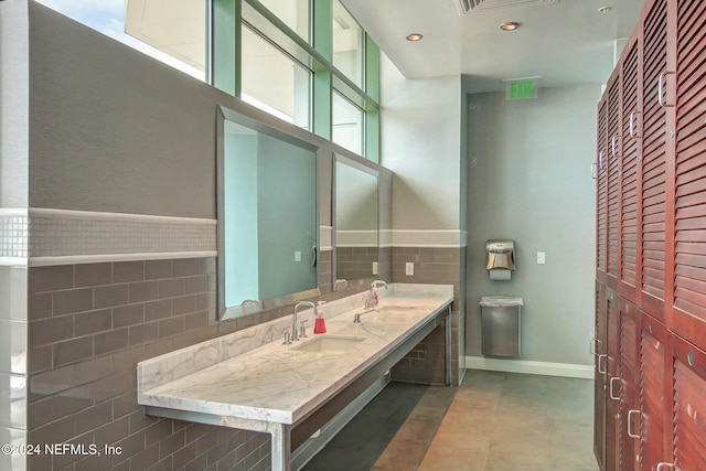 bathroom featuring tile walls, baseboards, wainscoting, recessed lighting, and vanity