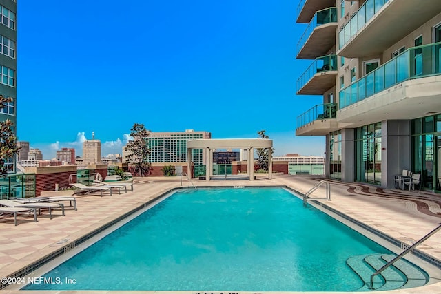 community pool featuring a view of city and a patio