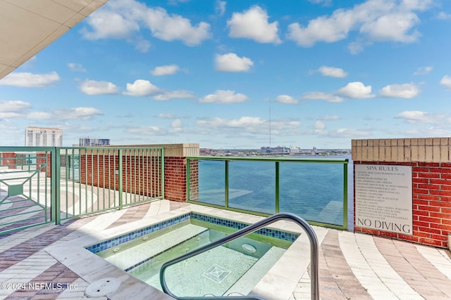 view of pool featuring a hot tub and a view of city