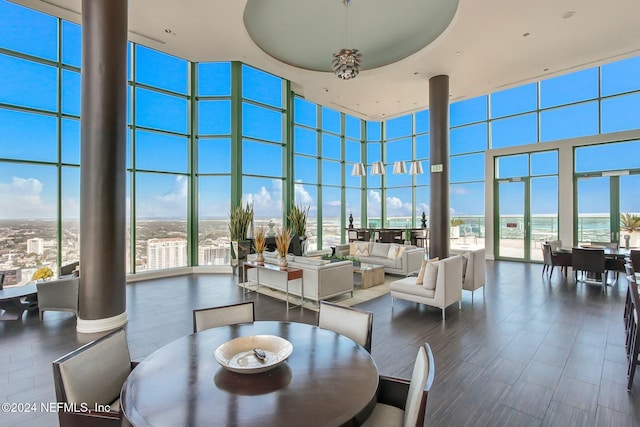 dining area with a high ceiling, a wall of windows, and healthy amount of natural light