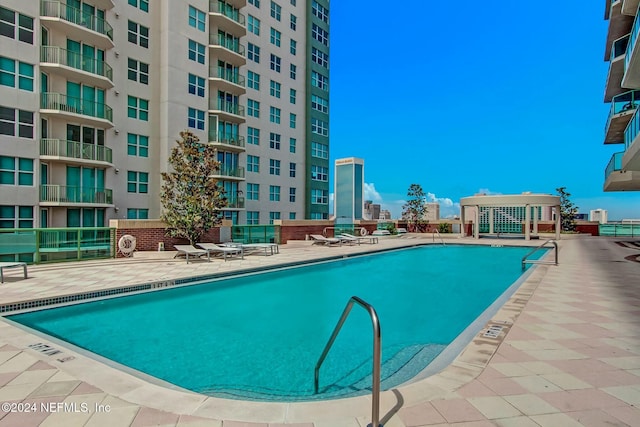 community pool featuring a patio and fence