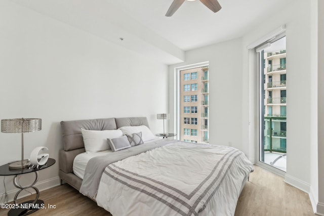 bedroom featuring access to outside, wood finished floors, baseboards, and a ceiling fan