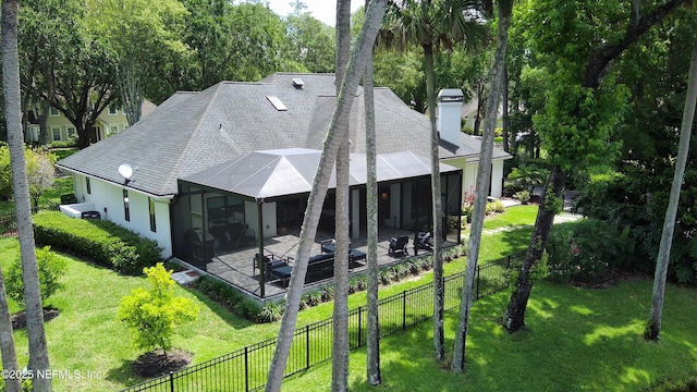 rear view of property featuring a patio area, roof with shingles, and a chimney