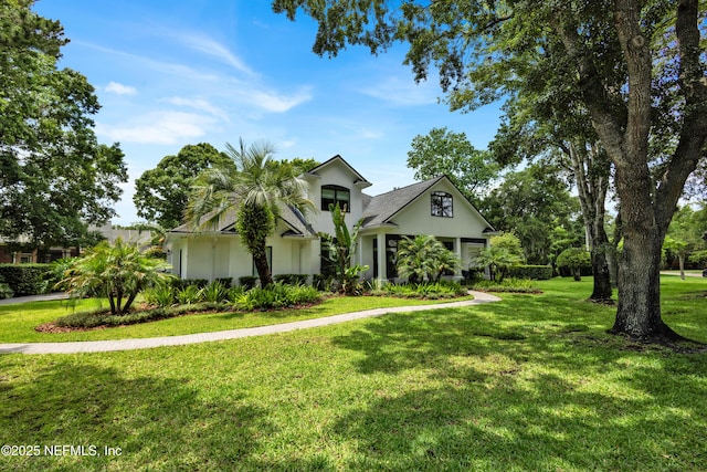 obstructed view of property featuring a front lawn and stucco siding