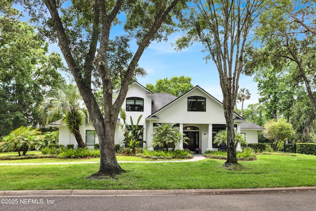 view of front of house featuring stucco siding and a front lawn