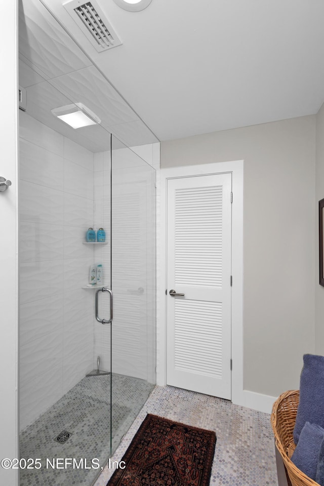 bathroom featuring a stall shower and baseboards