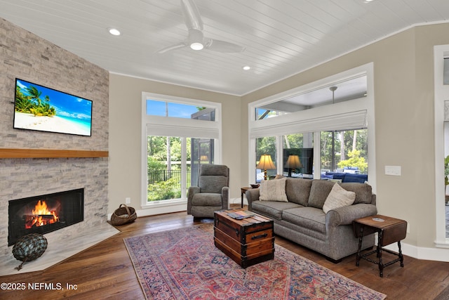 living area with a ceiling fan, hardwood / wood-style flooring, a fireplace, wood ceiling, and recessed lighting