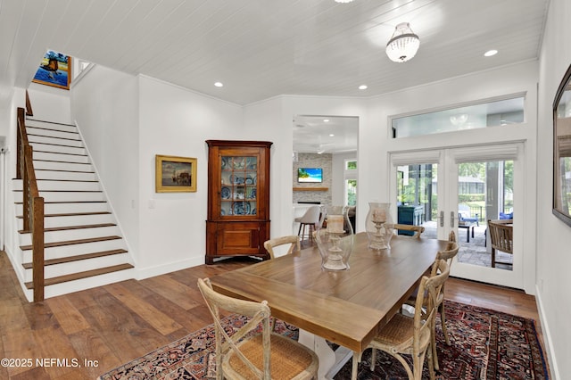 dining room featuring stairway, hardwood / wood-style flooring, baseboards, recessed lighting, and french doors