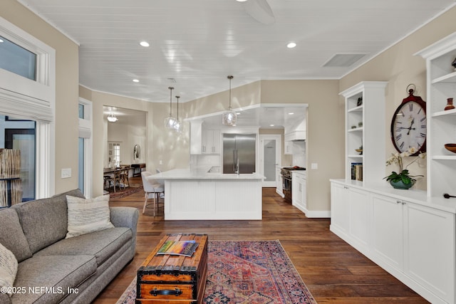 living room featuring dark wood-style floors, crown molding, and recessed lighting