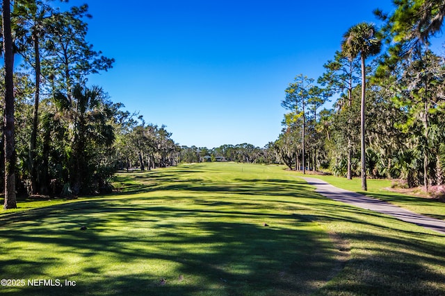 view of property's community with a yard and view of scattered trees