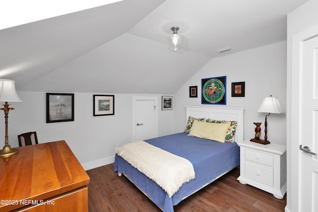 bedroom with dark wood-style floors, lofted ceiling, and baseboards