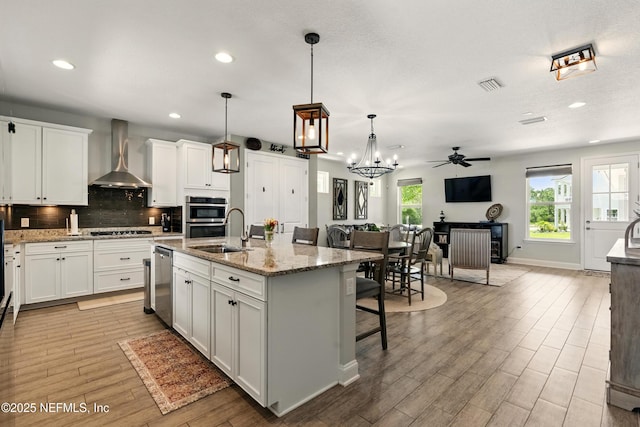 929 Keystone Corners Blvd, Saint Johns, FL 32259 - kitchen featuring wall chimney exhaust hood, a sink, open floor plan, a kitchen breakfast bar, and white cabinets