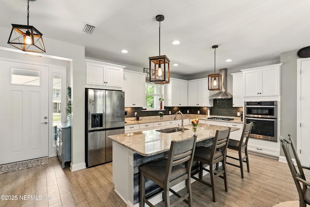 929 Keystone Corners Blvd, Saint Johns, FL 32259 - kitchen featuring stainless steel refrigerator with ice dispenser, a sink, wall chimney range hood, tasteful backsplash, and white cabinets