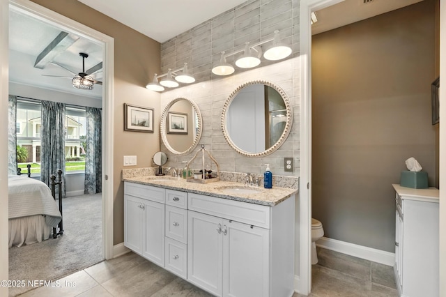 929 Keystone Corners Blvd, Saint Johns, FL 32259 - ensuite bathroom with double vanity, toilet, decorative backsplash, a ceiling fan, and baseboards