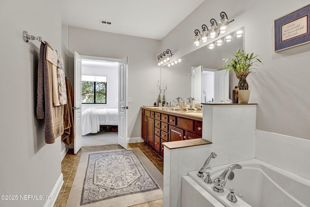 13527 Isla Vista Dr, Jacksonville, FL 32224 - bathroom featuring double vanity, a bath, baseboards, and connected bathroom