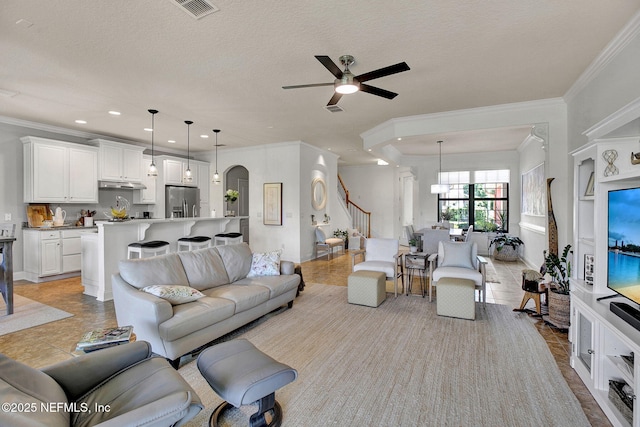 13527 Isla Vista Dr, Jacksonville, FL 32224 - living room featuring a ceiling fan, ornamental molding, a chandelier, arched walkways, and recessed lighting