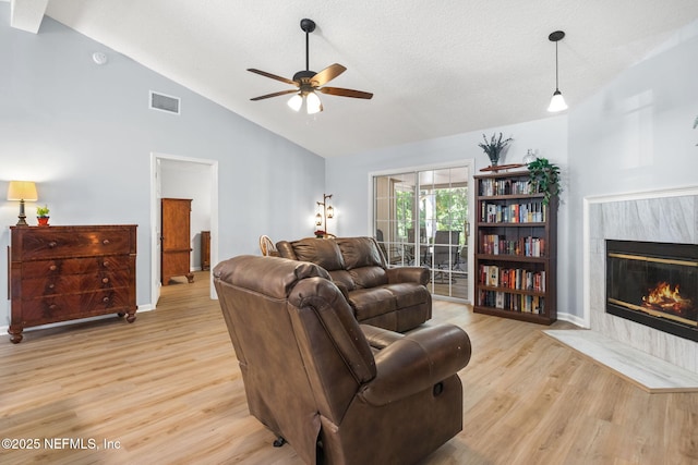 952 Long Lake Dr, Jacksonville, FL 32225 - living room featuring ceiling fan, light wood-type flooring, a tile fireplace, baseboards, and a textured ceiling